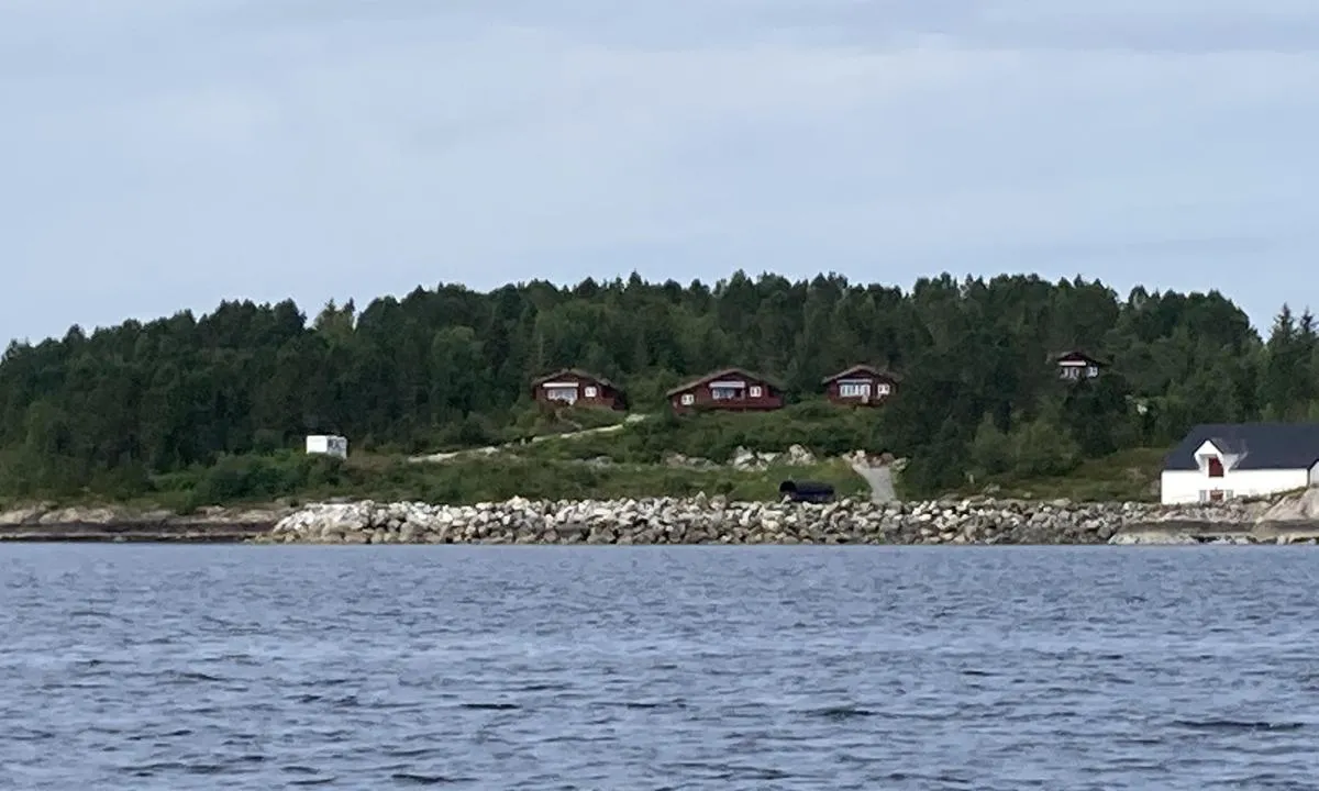 Fjellvær: Bildet tatt fra sjøsiden mot molo, brygge, utleiehytter og campingplass