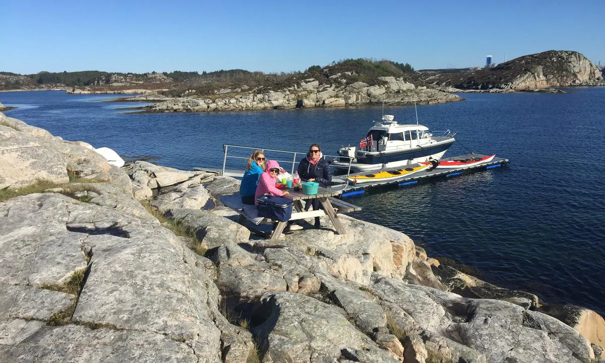 Skogsøy: Bord og benker ved flytebryggen.