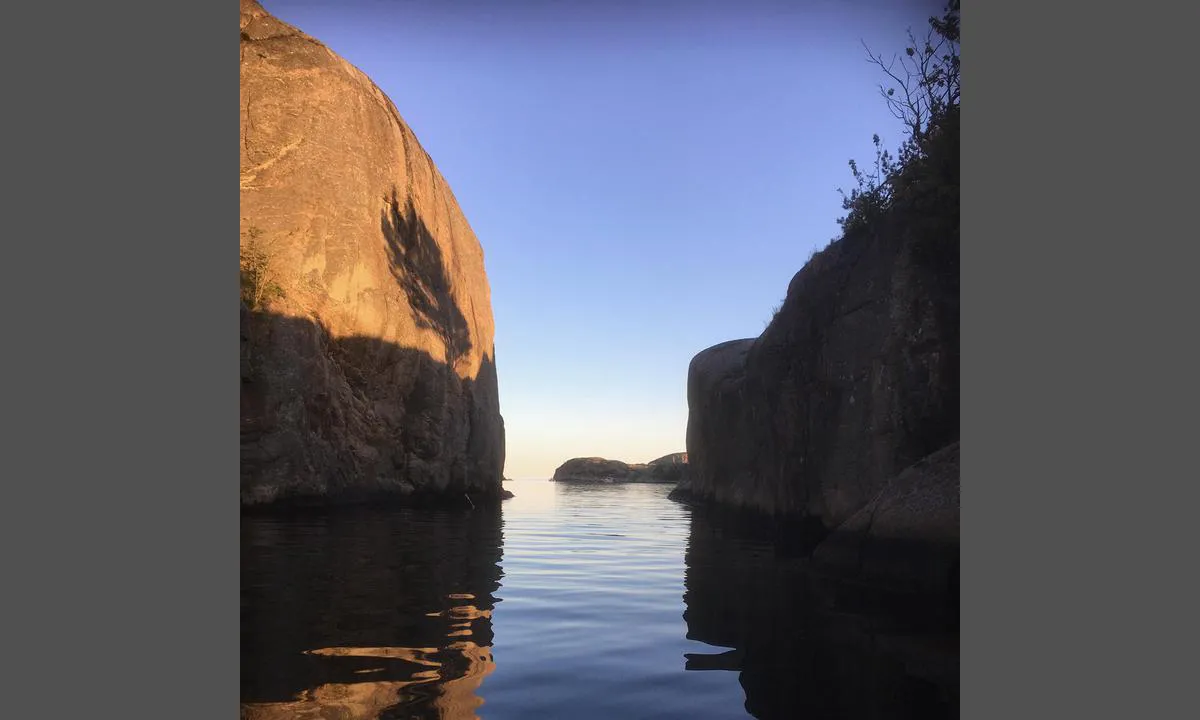 Ny-Hellesund - Olavsundet: Olavsundet en stille kveld. Pass på grunnen her øst i sundet! Merket med en liten stake. Strømledning med høyde på 12m. Skal du inn med seilbåt så seil inn fra sør. Bilde er tatt mot sør.