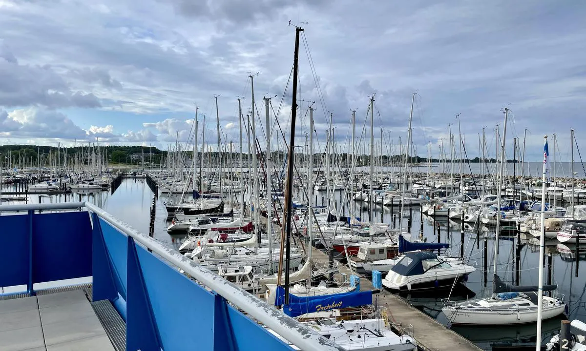 Olympiahafen Schilksee - Kiel: {"base": "no", "no": "Mot nord fra taket p\u00e5 havnekontoret", "se": "Mot norr fr\u00e5n taket p\u00e5 hamnkontoret", "en": "Towards the north from the roof of the harbour office", "da": "Mod nord fra taget p\u00e5 havnekontoret", "fr": "Vers le nord depuis le toit du bureau du port", "de": "Nach Norden vom Dach des Hafenb\u00fcros", "es": "Hacia el norte desde el techo de la oficina del puerto", "it": "Verso nord dal tetto dell'ufficio portuale", "pt": "Para o norte a partir do telhado do escrit\u00f3rio do porto", "nl": "Naar het noorden vanaf het dak van het havenkantoor", "pl": "Na p\u00f3\u0142noc od dachu urz\u0119du portowego", "uk": "\u041d\u0430 \u043f\u0456\u0432\u043d\u0456\u0447 \u0432\u0456\u0434 \u0434\u0430\u0445\u0443 \u043e\u0444\u0456\u0441\u0443 \u0433\u0430\u0432\u0430\u043d\u0456", "ro": "Spre nord de pe acoperi\u0219ul biroului portului", "tr": "Limana kuzeyden, liman idaresinin \u00e7at\u0131s\u0131ndan", "el": "\u03a0\u03c1\u03bf\u03c2 \u03b2\u03bf\u03c1\u03c1\u03ac \u03b1\u03c0\u03cc \u03c4\u03b7\u03bd \u03bf\u03c1\u03bf\u03c6\u03ae \u03c4\u03bf\u03c5 \u03bb\u03b9\u03bc\u03b5\u03bd\u03b1\u03c1\u03c7\u03b5\u03af\u03bf\u03c5", "cs": "Na sever ze st\u0159echy p\u0159\u00edstavn\u00ed kancel\u00e1\u0159e", "hu": "\u00c9szak fel\u00e9 a kik\u00f6t\u0151i hivatal tet\u0151j\u00e9r\u0151l", "fi": "Pohjoiseen satamakonttorin katolta", "bg": "\u041d\u0430 \u0441\u0435\u0432\u0435\u0440 \u043e\u0442 \u043f\u043e\u043a\u0440\u0438\u0432\u0430 \u043d\u0430 \u043f\u0440\u0438\u0441\u0442\u0430\u043d\u0438\u0449\u043d\u0430\u0442\u0430 \u043a\u0430\u043d\u0446\u0435\u043b\u0430\u0440\u0438\u044f", "sr": "Ka severu sa krova lu\u010dke kapetanije", "et": "P\u00f5hja suunas sadamakontori katuselt", "lv": "Uz zieme\u013ciem no ostas p\u0101rvaldes \u0113kas jumta", "lt": "\u012e \u0161iaur\u0119 nuo uosto biuro stogo"}