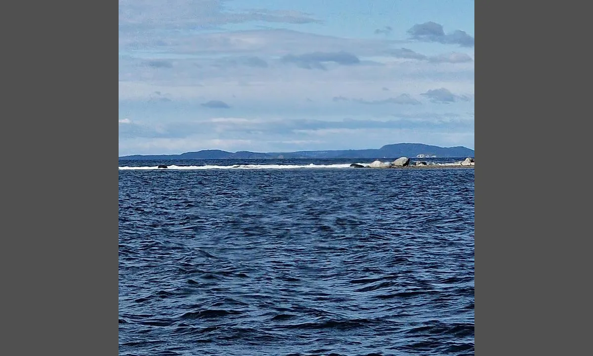 Omlid: Bilde tatt fra båten. Deilig å høre dønningene slå, mens man ligger på stille vann.