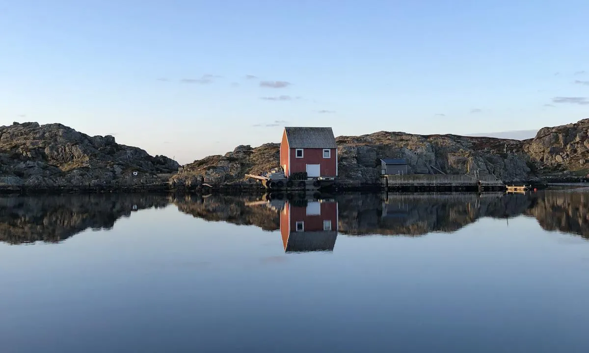 Blikkstille kveld i havna på Røvær. Utsikt fra ankringsplassen i midten.