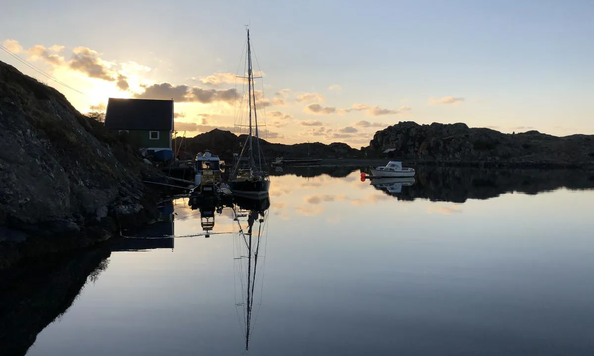 Solnedgang i bukta på Røvær. Til høyre i bildet er det god plass for å ligge på svai.