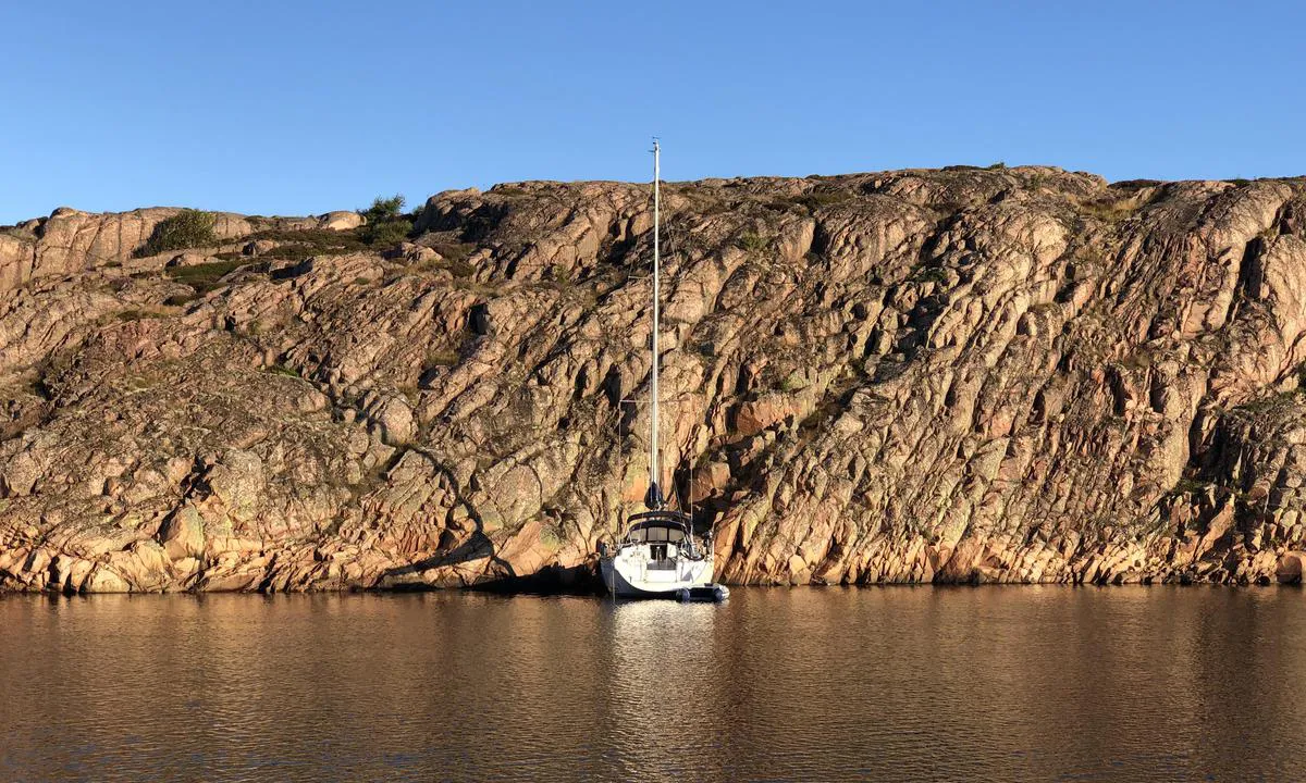 Sailboat moored bow-to towards the rocks on the north side of Sladholmen