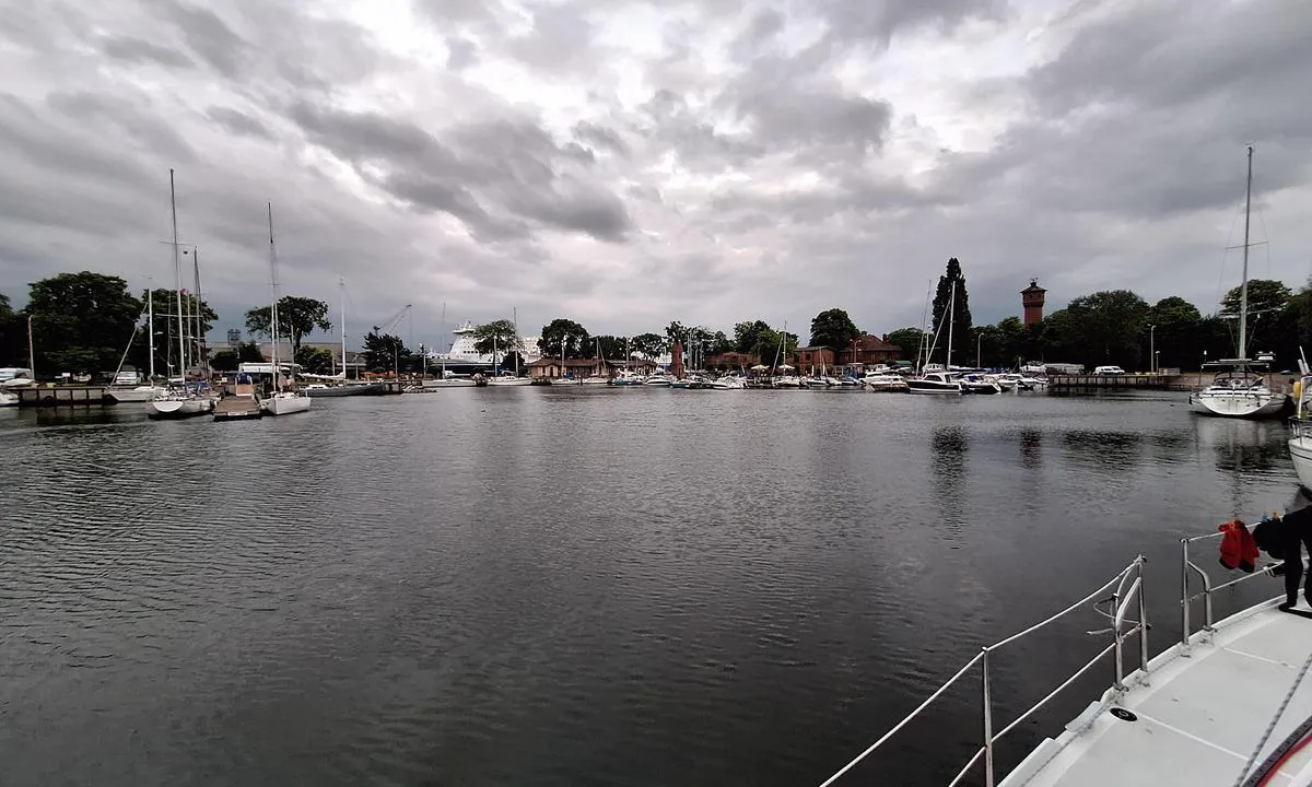 Świnoujście - Marina North Basin: {"base": "no", "no": "Indre del av havna, havnekontoret ligger omtrent midt i bildet. Det er fri wifi, men siden det er mang kluenter blir b\u00e5ndbredden lav. Ferjene som synes i bakgrunnen passerer rett utenfor, men lager ingen sj\u00f8 her inne. Det er to ferjer til Sverige hver dag, om ikke flere, s\u00e5 det er lett \u00e5 ta opp mannskap her.", "se": "Inre del av hamnen, hamnkontoret ligger ungef\u00e4r mitt i bilden. Det finns gratis wifi, men eftersom det finns m\u00e5nga klienter blir bandbredden l\u00e5g. F\u00e4rjorna som syns i bakgrunden passerar precis utanf\u00f6r, men skapar ingen sj\u00f6 h\u00e4r inne. Det g\u00e5r tv\u00e5 f\u00e4rjor till Sverige varje dag, om inte fler, s\u00e5 det \u00e4r l\u00e4tt att plocka upp bes\u00e4ttning h\u00e4r.", "en": "Inner part of the harbor, the harbor office is located roughly in the middle of the picture. There is free wifi, but since there are many clients, the bandwidth is low. The ferries visible in the background pass just outside, but they do not create any swell here. There are two ferries to Sweden every day, if not more, so it is easy to pick up crew here.", "da": "Den indre del af havnen, havnekontoret ligger omtrent midt i billedet. Der er gratis wifi, men siden der er mange klienter bliver b\u00e5ndbredden lav. F\u00e6rgerne som ses i baggrunden passerer lige udenfor, men laver ingen s\u00f8 her inde. Der er to f\u00e6rger til Sverige hver dag, eller flere, s\u00e5 det er let at tage mandskab p\u00e5 her.", "fr": "La partie int\u00e9rieure du port, le bureau du port est situ\u00e9 \u00e0 peu pr\u00e8s au centre de l'image. Il y a du wifi gratuit, mais comme il y a beaucoup de clients, la bande passante est faible. Les ferries que l'on peut voir en arri\u00e8re-plan passent juste \u00e0 l'ext\u00e9rieur, mais ils ne causent aucune houle ici \u00e0 l'int\u00e9rieur. Il y a deux ferries pour la Su\u00e8de chaque jour, voire plus, il est donc facile de recruter du personnel ici.", "de": "Der innere Hafenbereich, das Hafenkontor liegt etwa in der Mitte des Bildes. Es gibt kostenloses WLAN, aber aufgrund der vielen Kunden ist die Bandbreite gering. Die F\u00e4hren, die im Hintergrund zu sehen sind, fahren direkt drau\u00dfen vorbei, verursachen jedoch hier drinnen keine Wellen. Es gibt t\u00e4glich zwei F\u00e4hren nach Schweden, wenn nicht sogar mehr, daher ist es leicht, hier die Besatzung aufzunehmen.", "es": "La parte interior del puerto, la oficina del puerto se encuentra aproximadamente en el centro de la imagen. Hay wifi gratis, pero debido a la cantidad de clientes, el ancho de banda es bajo. Los ferris que se ven al fondo pasan justo afuera, pero no crean oleaje aqu\u00ed dentro. Hay dos ferris a Suecia cada d\u00eda, si no m\u00e1s, por lo que es f\u00e1cil recoger tripulaci\u00f3n aqu\u00ed.", "it": "La parte interna del porto, l'ufficio portuale si trova circa al centro dell'immagine. C'\u00e8 il wifi gratuito, ma poich\u00e9 ci sono molti clienti, la larghezza di banda \u00e8 bassa. I traghetti che si vedono sullo sfondo passano appena fuori, ma non creano onde qui dentro. Ci sono due traghetti per la Svezia ogni giorno, se non di pi\u00f9, quindi \u00e8 facile imbarcare l'equipaggio qui.", "pt": "Parte interna do porto, o escrit\u00f3rio portu\u00e1rio est\u00e1 localizado aproximadamente no meio da imagem. H\u00e1 wifi gratuito, mas como h\u00e1 muitos clientes, a largura de banda \u00e9 baixa. Os ferries que podem ser vistos ao fundo passam bem ao lado, mas n\u00e3o criam ondas aqui dentro. H\u00e1 dois ferries para a Su\u00e9cia todos os dias, sen\u00e3o mais, por isso \u00e9 f\u00e1cil pegar a tripula\u00e7\u00e3o aqui.", "nl": "Het binnenste deel van de haven, het havenkantoor ligt ongeveer in het midden van de afbeelding. Er is gratis wifi, maar omdat er veel klanten zijn, is de bandbreedte laag. De veerboten die op de achtergrond te zien zijn, varen direct buitenlangs, maar veroorzaken hier binnen geen deining. Er zijn elke dag twee veerboten naar Zweden, zo niet meer, dus het is gemakkelijk om hier bemanning op te pikken.", "pl": "Wewn\u0119trzna cz\u0119\u015b\u0107 portu, biuro portowe znajduje si\u0119 mniej wi\u0119cej w \u015brodku obrazu. Jest darmowe wifi, ale z powodu du\u017cej ilo\u015bci klient\u00f3w, przepustowo\u015b\u0107 jest niska. Promy widoczne w tle przep\u0142ywaj\u0105 tu\u017c na zewn\u0105trz, ale nie powoduj\u0105 fal w tej cz\u0119\u015bci. Codziennie kursuj\u0105 dwa promy do Szwecji, je\u015bli nie wi\u0119cej, wi\u0119c \u0142atwo mo\u017cna tutaj zabra\u0107 za\u0142og\u0119.", "uk": "\u0412\u043d\u0443\u0442\u0440\u0456\u0448\u043d\u044f \u0447\u0430\u0441\u0442\u0438\u043d\u0430 \u0433\u0430\u0432\u0430\u043d\u0456, \u043e\u0444\u0456\u0441 \u0433\u0430\u0432\u0430\u043d\u0456 \u0437\u043d\u0430\u0445\u043e\u0434\u0438\u0442\u044c\u0441\u044f \u043f\u0440\u0438\u0431\u043b\u0438\u0437\u043d\u043e \u043f\u043e\u0441\u0435\u0440\u0435\u0434\u0438\u043d\u0456 \u0437\u043e\u0431\u0440\u0430\u0436\u0435\u043d\u043d\u044f. \u0404 \u0431\u0435\u0437\u043a\u043e\u0448\u0442\u043e\u0432\u043d\u0438\u0439 Wi-Fi, \u0430\u043b\u0435 \u043e\u0441\u043a\u0456\u043b\u044c\u043a\u0438 \u0431\u0430\u0433\u0430\u0442\u043e \u043a\u043b\u0456\u0454\u043d\u0442\u0456\u0432, \u043f\u0440\u043e\u043f\u0443\u0441\u043a\u043d\u0430 \u0437\u0434\u0430\u0442\u043d\u0456\u0441\u0442\u044c \u043d\u0438\u0437\u044c\u043a\u0430. \u041f\u043e\u0440\u043e\u043c\u0438, \u044f\u043a\u0456 \u0432\u0438\u0434\u043d\u043e \u043d\u0430 \u0437\u0430\u0434\u043d\u044c\u043e\u043c\u0443 \u043f\u043b\u0430\u043d\u0456, \u043f\u0440\u043e\u0445\u043e\u0434\u044f\u0442\u044c \u043f\u0440\u044f\u043c\u043e \u0437\u043e\u0432\u043d\u0456, \u0430\u043b\u0435 \u043d\u0435 \u0441\u0442\u0432\u043e\u0440\u044e\u044e\u0442\u044c \u0445\u0432\u0438\u043b\u044c \u0442\u0443\u0442 \u0432\u0441\u0435\u0440\u0435\u0434\u0438\u043d\u0456. \u0404 \u0434\u0432\u0430 \u043f\u043e\u0440\u043e\u043c\u0438 \u0434\u043e \u0428\u0432\u0435\u0446\u0456\u0457 \u043a\u043e\u0436\u043d\u043e\u0433\u043e \u0434\u043d\u044f, \u044f\u043a\u0449\u043e \u043d\u0435 \u0431\u0456\u043b\u044c\u0448\u0435, \u0442\u043e\u043c\u0443 \u043b\u0435\u0433\u043a\u043e \u043f\u0440\u0438\u0439\u043d\u044f\u0442\u0438 \u0435\u043a\u0456\u043f\u0430\u0436 \u0442\u0443\u0442.", "ro": "Partea interioar\u0103 a portului, biroul portuar se afl\u0103 aproximativ \u00een mijlocul imaginii. Exist\u0103 wifi gratuit, dar deoarece sunt mul\u021bi utilizatori, l\u0103\u021bimea de band\u0103 este mic\u0103. Feriboturile care se v\u0103d \u00een fundal trec chiar \u00een afar\u0103, dar nu produc valuri aici. Sunt dou\u0103 feriboturi pentru Suedia \u00een fiecare zi, dac\u0103 nu mai multe, astfel \u00eenc\u00e2t este u\u0219or s\u0103 \u00eembarci echipajul aici.", "tr": "Liman\u0131n i\u00e7 k\u0131sm\u0131, liman ofisi yakla\u015f\u0131k olarak resmin ortas\u0131nda bulunmaktad\u0131r. \u00dccretsiz wifi var, ancak bir\u00e7ok kullan\u0131c\u0131 oldu\u011fu i\u00e7in bant geni\u015fli\u011fi d\u00fc\u015f\u00fckt\u00fcr. Arka planda g\u00f6r\u00fcnen feribotlar d\u0131\u015far\u0131dan ge\u00e7er, ancak burada i\u00e7eride deniz yaratmazlar. \u0130sve\u00e7'e her g\u00fcn iki feribot vard\u0131r, belki daha fazla, bu nedenle burada m\u00fcrettebat almak kolayd\u0131r.", "el": "\u03a3\u03c4\u03bf \u03b5\u03c3\u03c9\u03c4\u03b5\u03c1\u03b9\u03ba\u03cc \u03bc\u03ad\u03c1\u03bf\u03c2 \u03c4\u03bf\u03c5 \u03bb\u03b9\u03bc\u03b1\u03bd\u03b9\u03bf\u03cd, \u03c4\u03bf \u03bb\u03b9\u03bc\u03b5\u03bd\u03b9\u03ba\u03cc \u03b3\u03c1\u03b1\u03c6\u03b5\u03af\u03bf \u03b2\u03c1\u03af\u03c3\u03ba\u03b5\u03c4\u03b1\u03b9 \u03c0\u03b5\u03c1\u03af\u03c0\u03bf\u03c5 \u03c3\u03c4\u03b7 \u03bc\u03ad\u03c3\u03b7 \u03c4\u03b7\u03c2 \u03b5\u03b9\u03ba\u03cc\u03bd\u03b1\u03c2. \u03a5\u03c0\u03ac\u03c1\u03c7\u03b5\u03b9 \u03b4\u03c9\u03c1\u03b5\u03ac\u03bd wifi, \u03b1\u03bb\u03bb\u03ac \u03b5\u03c0\u03b5\u03b9\u03b4\u03ae \u03c5\u03c0\u03ac\u03c1\u03c7\u03bf\u03c5\u03bd \u03c0\u03bf\u03bb\u03bb\u03bf\u03af \u03c0\u03b5\u03bb\u03ac\u03c4\u03b5\u03c2, \u03c4\u03bf \u03b5\u03cd\u03c1\u03bf\u03c2 \u03b6\u03ce\u03bd\u03b7\u03c2 \u03b5\u03af\u03bd\u03b1\u03b9 \u03c7\u03b1\u03bc\u03b7\u03bb\u03cc. \u03a4\u03b1 \u03c0\u03bb\u03bf\u03af\u03b1 \u03c0\u03bf\u03c5 \u03c6\u03b1\u03af\u03bd\u03bf\u03bd\u03c4\u03b1\u03b9 \u03c3\u03c4\u03bf \u03c6\u03cc\u03bd\u03c4\u03bf \u03c0\u03b5\u03c1\u03bd\u03bf\u03cd\u03bd \u03b1\u03ba\u03c1\u03b9\u03b2\u03ce\u03c2 \u03b1\u03c0\u03ad\u03be\u03c9, \u03b1\u03bb\u03bb\u03ac \u03b4\u03b5\u03bd \u03b4\u03b7\u03bc\u03b9\u03bf\u03c5\u03c1\u03b3\u03bf\u03cd\u03bd \u03ba\u03cd\u03bc\u03b1\u03c4\u03b1 \u03b5\u03b4\u03ce \u03bc\u03ad\u03c3\u03b1. \u03a5\u03c0\u03ac\u03c1\u03c7\u03bf\u03c5\u03bd \u03b4\u03cd\u03bf \u03c0\u03bb\u03bf\u03af\u03b1 \u03c0\u03c1\u03bf\u03c2 \u03a3\u03bf\u03c5\u03b7\u03b4\u03af\u03b1 \u03ba\u03ac\u03b8\u03b5 \u03bc\u03ad\u03c1\u03b1, \u03b1\u03bd \u03cc\u03c7\u03b9 \u03c0\u03b5\u03c1\u03b9\u03c3\u03c3\u03cc\u03c4\u03b5\u03c1\u03b1, \u03ad\u03c4\u03c3\u03b9 \u03b5\u03af\u03bd\u03b1\u03b9 \u03b5\u03cd\u03ba\u03bf\u03bb\u03bf \u03bd\u03b1 \u03c0\u03ac\u03c1\u03b5\u03b9 \u03ba\u03b1\u03bd\u03b5\u03af\u03c2 \u03c0\u03c1\u03bf\u03c3\u03c9\u03c0\u03b9\u03ba\u03cc \u03b5\u03b4\u03ce.", "cs": "Vnit\u0159n\u00ed \u010d\u00e1st p\u0159\u00edstavu, p\u0159\u00edstavn\u00ed \u00fa\u0159ad je zhruba uprost\u0159ed sn\u00edmku. K dispozici je voln\u00e1 wifi, ale vzhledem k vysok\u00e9mu po\u010dtu klient\u016f je \u0161\u00ed\u0159ka p\u00e1sma n\u00edzk\u00e1. Trajekty, kter\u00e9 jsou vid\u011bt v pozad\u00ed, proj\u00ed\u017ed\u011bj\u00ed hned za p\u0159\u00edstavem, ale nezp\u016fsobuj\u00ed zde \u017e\u00e1dn\u00e9 vln\u011bn\u00ed. Ka\u017ed\u00fd den jezd\u00ed do \u0160v\u00e9dska dva trajekty, a mo\u017en\u00e1 i v\u00edce, tak\u017ee je snadn\u00e9 zde p\u0159ijmout pos\u00e1dku.", "hu": "<p>A kik\u00f6t\u0151 bels\u0151 r\u00e9sze, a kik\u00f6t\u0151i iroda k\u00f6r\u00fclbel\u00fcl k\u00f6z\u00e9pen tal\u00e1lhat\u00f3 a k\u00e9pen. Van ingyenes wifi, de mivel sok a felhaszn\u00e1l\u00f3, a s\u00e1vsz\u00e9less\u00e9g alacsony. A h\u00e1tt\u00e9rben l\u00e1that\u00f3 komphaj\u00f3k k\u00f6zvetlen\u00fcl k\u00edv\u00fcl haladnak el, de itt bent nem okoznak hull\u00e1mz\u00e1st. Minden nap k\u00e9t komp j\u00e1r Sv\u00e9dorsz\u00e1gba, vagy ak\u00e1r t\u00f6bb is, \u00edgy k\u00f6nny\u0171 itt leg\u00e9nys\u00e9get tal\u00e1lni.</p>", "fi": "Sataman sis\u00e4osa, satamatoimisto sijaitsee suunnilleen keskell\u00e4 kuvaa. Wifi on vapaa, mutta koska on niin monta k\u00e4ytt\u00e4j\u00e4\u00e4, kaistanleveys on alhainen. Taustalla n\u00e4kyv\u00e4t lautat kulkevat juuri sataman ulkopuolella, mutta eiv\u00e4t aiheuta merenk\u00e4ynti\u00e4 t\u00e4\u00e4ll\u00e4 sis\u00e4ll\u00e4. Lauttoja Ruotsiin menee p\u00e4ivitt\u00e4in kaksi, ellei useampia, joten on helppo nostaa miehist\u00f6\u00e4 t\u00e4\u00e4ll\u00e4.", "bg": "\u0412\u044a\u0442\u0440\u0435\u0448\u043d\u0430\u0442\u0430 \u0447\u0430\u0441\u0442 \u043d\u0430 \u043f\u0440\u0438\u0441\u0442\u0430\u043d\u0438\u0449\u0435\u0442\u043e, \u043f\u0440\u0438\u0441\u0442\u0430\u043d\u0438\u0449\u043d\u0430\u0442\u0430 \u0441\u043b\u0443\u0436\u0431\u0430 \u0441\u0435 \u043d\u0430\u043c\u0438\u0440\u0430 \u043f\u0440\u0438\u0431\u043b\u0438\u0437\u0438\u0442\u0435\u043b\u043d\u043e \u0432 \u0446\u0435\u043d\u0442\u044a\u0440\u0430 \u043d\u0430 \u0441\u043d\u0438\u043c\u043a\u0430\u0442\u0430. \u0418\u043c\u0430 \u0431\u0435\u0437\u043f\u043b\u0430\u0442\u0435\u043d Wi-Fi, \u043d\u043e \u043f\u043e\u043d\u0435\u0436\u0435 \u0438\u043c\u0430 \u043c\u043d\u043e\u0433\u043e \u043a\u043b\u0438\u0435\u043d\u0442\u0438, \u0447\u0435\u0441\u0442\u043e\u0442\u043d\u0430\u0442\u0430 \u043b\u0435\u043d\u0442\u0430 \u0435 \u043d\u0438\u0441\u043a\u0430. \u0424\u0435\u0440\u0438\u0431\u043e\u0442\u0438\u0442\u0435, \u043a\u043e\u0438\u0442\u043e \u0441\u0435 \u0432\u0438\u0436\u0434\u0430\u0442 \u043d\u0430 \u0437\u0430\u0434\u0435\u043d \u043f\u043b\u0430\u043d, \u043c\u0438\u043d\u0430\u0432\u0430\u0442 \u0442\u043e\u0447\u043d\u043e \u043e\u0442\u0432\u044a\u043d, \u043d\u043e \u043d\u0435 \u0441\u044a\u0437\u0434\u0430\u0432\u0430\u0442 \u0432\u044a\u043b\u043d\u0438 \u0442\u0443\u043a. \u0418\u043c\u0430 \u0434\u0432\u0430 \u0444\u0435\u0440\u0438\u0431\u043e\u0442\u0430 \u0434\u043e \u0428\u0432\u0435\u0446\u0438\u044f \u0432\u0441\u0435\u043a\u0438 \u0434\u0435\u043d, \u0430\u043a\u043e \u043d\u0435 \u0438 \u043f\u043e\u0432\u0435\u0447\u0435, \u0442\u0430\u043a\u0430 \u0447\u0435 \u0435 \u043b\u0435\u0441\u043d\u043e \u0434\u0430 \u0441\u0435 \u043a\u0430\u0447\u0438 \u0435\u043a\u0438\u043f\u0430\u0436 \u0442\u0443\u043a.", "sr": "Unutra\u0161nji deo luke, lu\u010dka kancelarija se nalazi otprilike na sredini slike. Postoji besplatan WiFi, ali zbog velikog broja korisnika \u0161irina pojasa je mala. Trajekti koji se vide u pozadini prolaze tik ispred, ali ne stvaraju talase ovde unutra. Svakog dana ima dva trajekta za \u0160vedsku, ako ne i vi\u0161e, tako da je lako ukrcati posadu ovde.", "et": "Sisemaal sadamast, sadamakontor asub umbes keskel pildil. WiFi on vaba, kuid kuna on palju kliente, on ribalaius madal. Taustal n\u00e4ha olevad parvlaevad s\u00f5idavad otse m\u00f6\u00f6da, kuid ei tekita siin sees lainetust. Rootsi v\u00e4ljub kaks parvlaeva iga p\u00e4ev, kui mitte rohkem, nii et meeskonda on siin lihtne v\u00f5tta.", "lv": "Iek\u0161\u0113j\u0101 ostas da\u013ca, ostas birojs atrodas aptuveni vid\u016b att\u0113l\u0101. Ir pieejams bezmaksas wifi, bet t\u0101 k\u0101 ir daudz klientu, joslas platums ir zems. Pr\u0101mji, kas ir redzami fon\u0101, kurs\u0113 tie\u0161i \u0101rpus\u0113, bet \u0161eit iek\u0161pus\u0113 neveido vi\u013c\u0146us. Katru dienu uz Zviedriju brauc divi pr\u0101mji, ja ne vair\u0101k, t\u0101p\u0113c ir viegli uz\u0146emt apkalpi \u0161eit.", "lt": "Vidin\u0117 uosto dalis, uosto kontora yra ma\u017edaug nuotraukos viduryje. Yra nemokamas wifi, bet d\u0117l daugyb\u0117s klient\u0173 pla\u010diajuos\u010dio ry\u0161io greitis yra ma\u017eas. Kelto, matomo fone, mar\u0161rutas eina tiesiai u\u017e uosto, bet \u010dia viduje jis nesukelia bangavimo. Kasdien \u012f \u0160vedij\u0105 kursuoja du arba daugiau keltai, tod\u0117l lengva \u010dia pasiimti \u012fgul\u0105."}